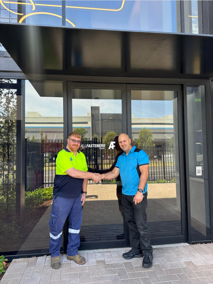 CJM team members shaking hands outside a client site